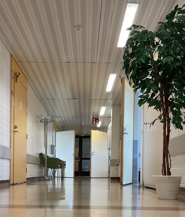 Bild av korridor med vita väggar, beige golv och gula öppna dörrar