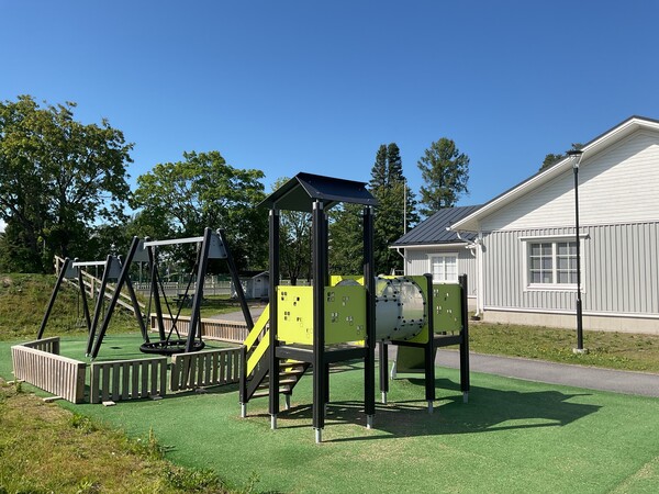 Esikoulun piha, missä on keinuja, hämähäkkikeinu ja kiipeilyteline