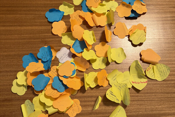 På ett bord ligger en stor hög postit-lappar med nerskrivna idéer.