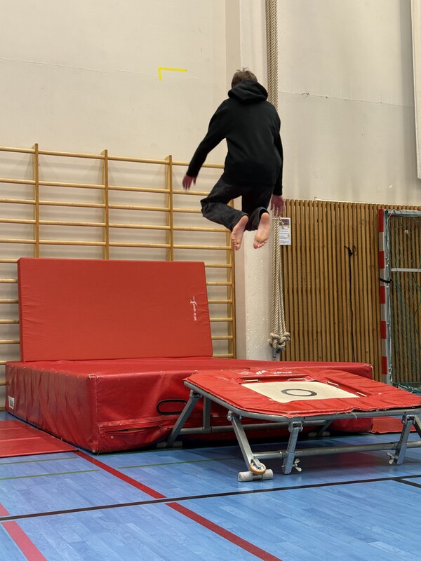 Elev hoppar på trampolin och landar på en madrass.