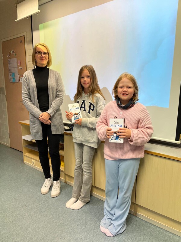 Flickorna står tillsammans med undervisningschefen.